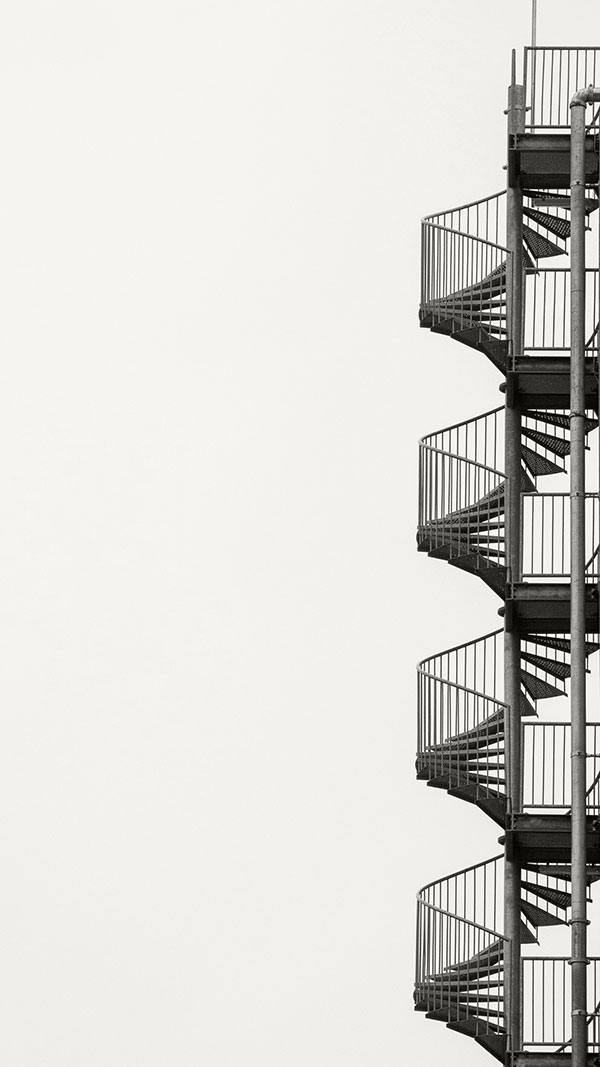 Sehr hohe und steile Metall-Wendeltreppe an Außenseite eines Hauses